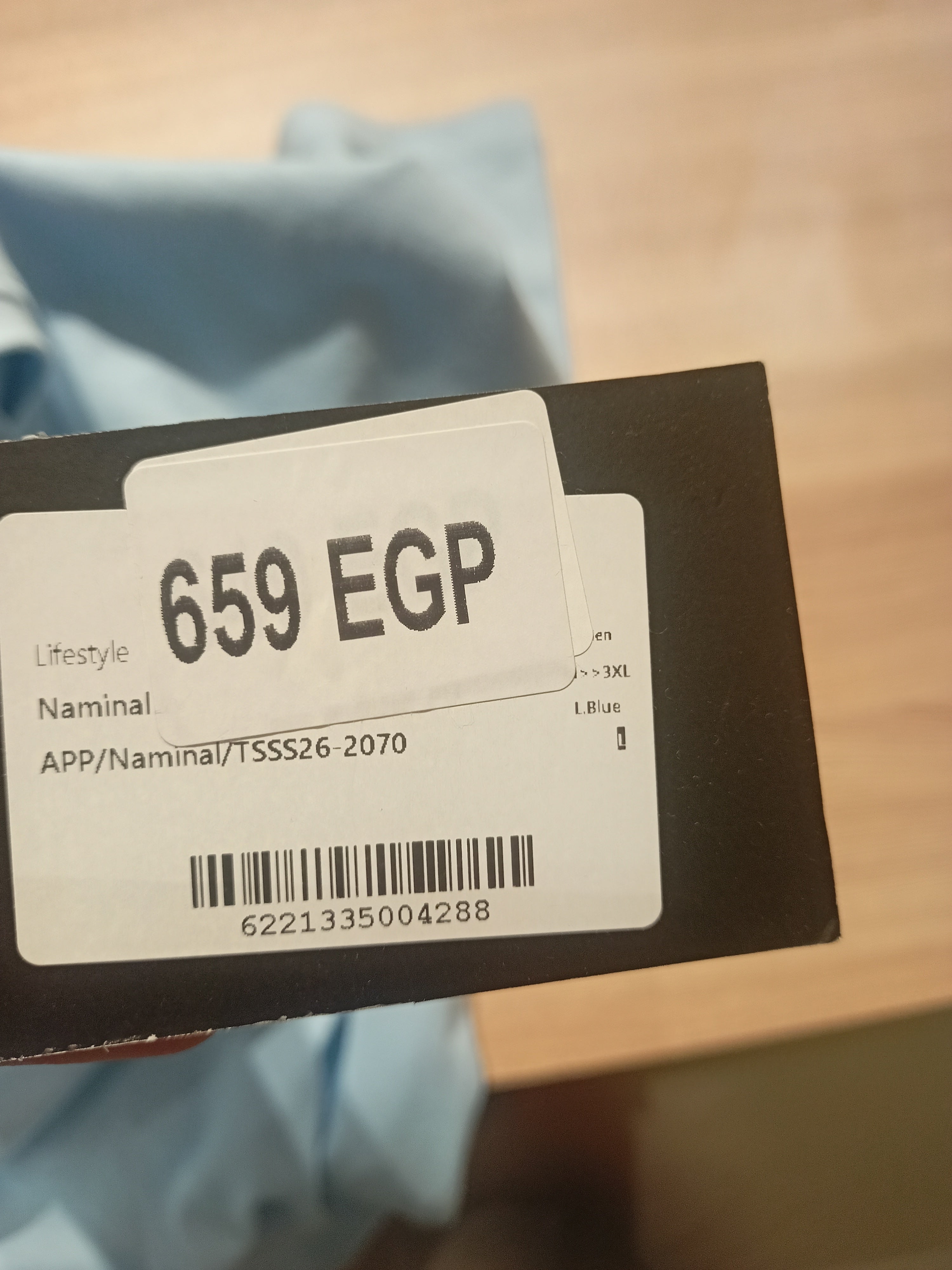 Clothing label with price and product details on a blurred background