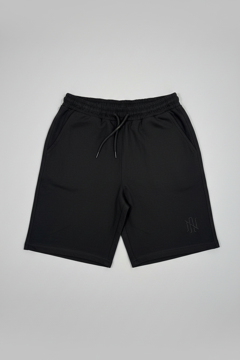 Black shorts with a small logo on a light gray background